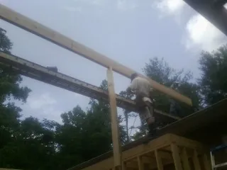 Carpenter setting a ridge beam over a new addition frame — Ice Dam Removal by Roofing Brothers in Shadyside