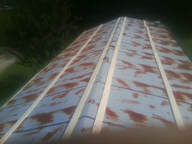 Rusted metal roof panels with new wood purlins before replacement — Storm Damage Roof Repair in Shadyside by Roofing Brothers