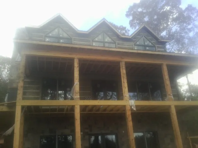 Dormers and porch framing on a large log home under construction — Roof Coating work by our crew in Shadyside