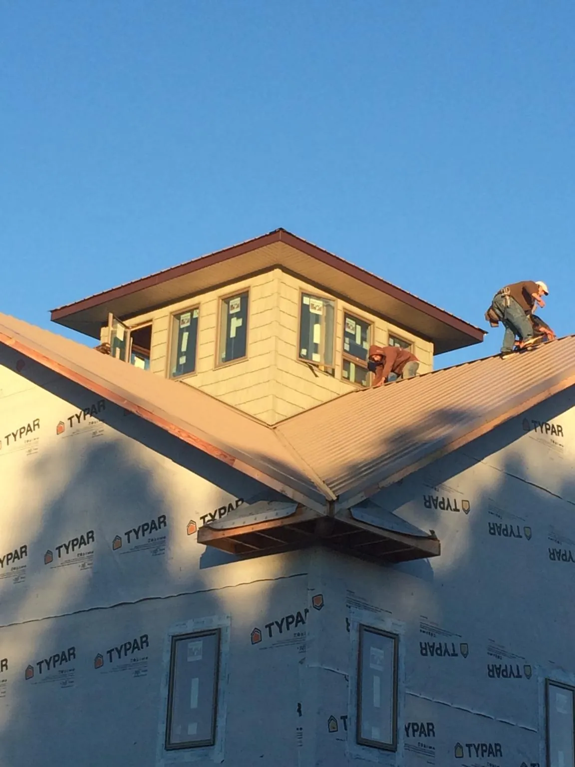 Roofers working around a rooftop cupola on a new metal roof at sunset — Roof Waterproofing in Shadyside by Roofing Brothers